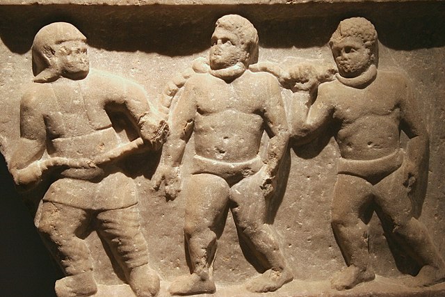 Marble relief of slaves in chains 